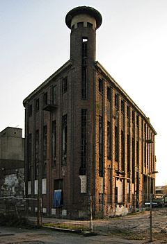 Bild: Lagergebäude mit Howinol-Turm im Abendlicht - Holtz & Willemsen Ölfabriken (März 2002)