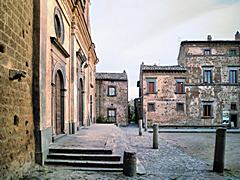 Bild: Civita di Bagnoregio - Piazza San Donato, vor der Kirche (<a href=https://www.google.com/maps/@42.6279135,12.1137326,2a,75y,173.89h,98.24t/data=!3m6!1e1!3m4!1s-mzN-VLUrcpXiWCeZvjATg!2e0!7i13312!8i6656 target=_blank>Streetview</a>)